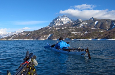 Alors que nous naviguons les skis et bâtons fixés sur les ponts de nos kayaks, le vent de nord-est en altitude couche les nuages qui les thermiques forment au sommet du Morgon qui domine le lac de 1500m !