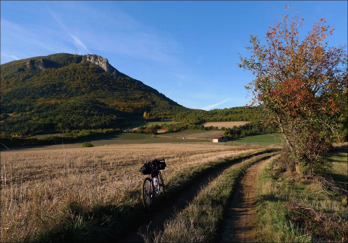 Premiers tours de roue, les lumières rasantes réchauffent le paysage et le cycliste.