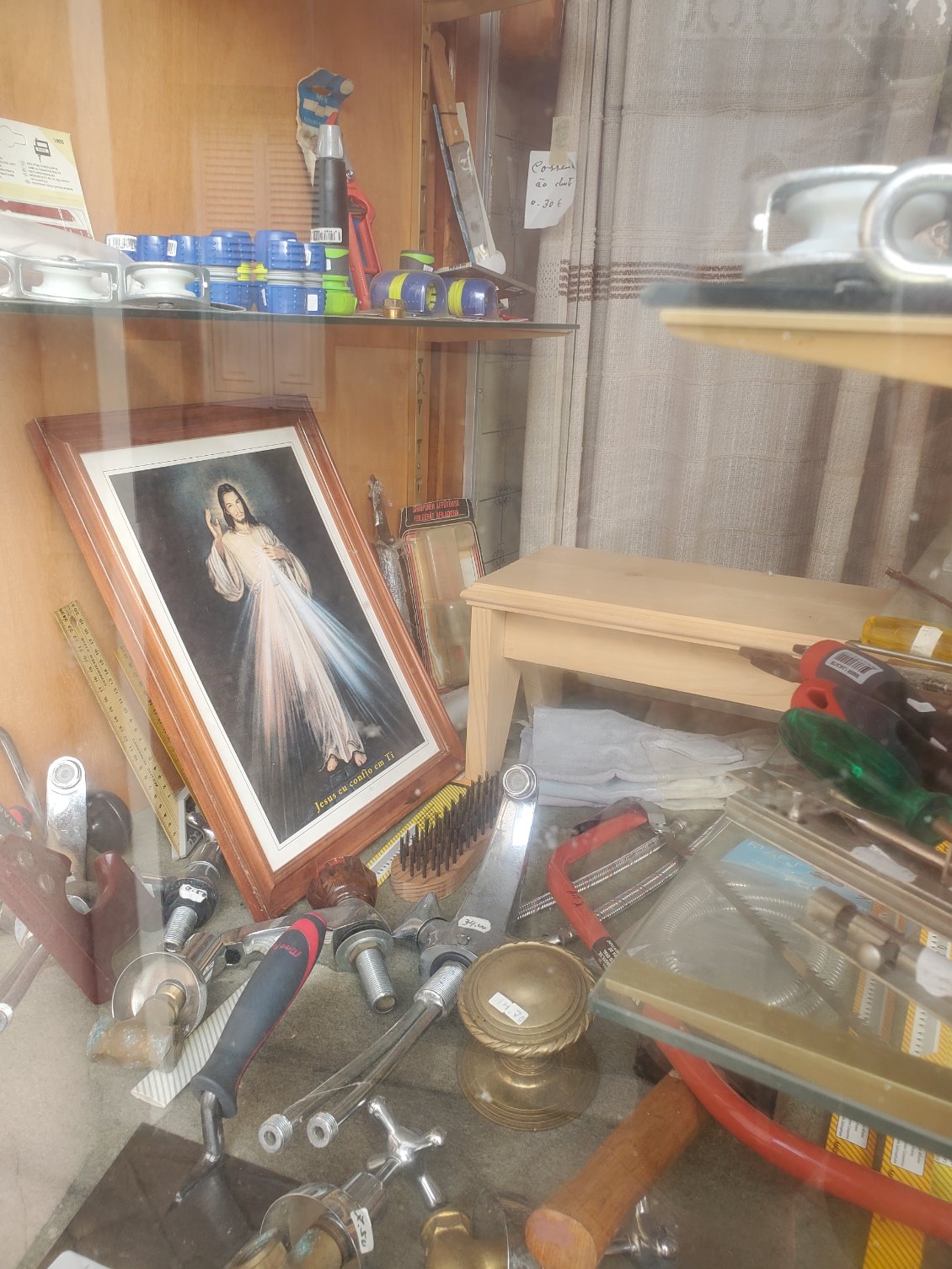 Dans Les vitrines de tous les magasins on trouve des images saintes au milieu de bric et de broc.