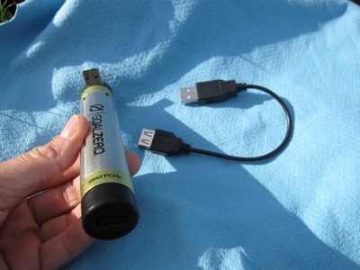 Au premier plan, la sortie USB femelle pour charger un appareil. A l'autre bout l'entrée USB mâle (repliable) pour recharger la batterie. + câble fourni