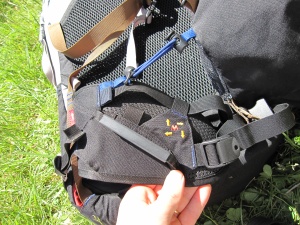 Vue latérale de la ceinture ventrale, avec un porte-matériel et, en bleu, un des points de connexion de la poche avant Vue latérale de la ceinture ventrale, avec un porte-matériel et, en bleu, un des points de connexion de la poche avant