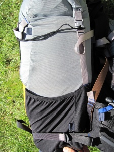 Vue latérale du sac, avec poche en tissu élastique et sangle de compression (reliée à la ventrale) Vue latérale du sac, avec poche en tissu élastique et sangle de compression (reliée à la ventrale)