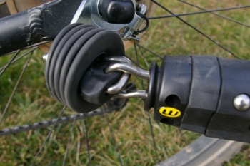 Fixation  au vélo : système Weber articulé et sécurisé avec un câble en acier, facile à mettre en place mais d'expérience (sur remorque Weber Monoporter) fragile