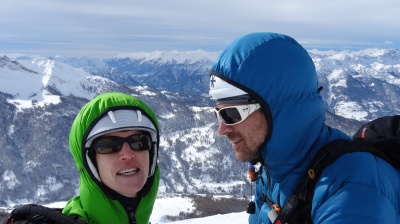 La capuche des modèles Thermik light (en vert) et Thermik light réversible (bleu) est assez ample pour permettre le port d'un casque (ici des casques de ski, très proches de casques de parapente)