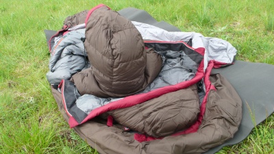  grosse capuche ajustée (type doudoune), se prolongeant sur la poitrine, cousue dans le sac interne à hauteur des épaules et qui remplace la traditionnelle collerette.