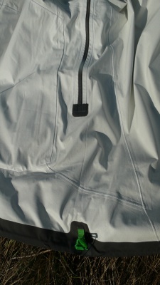 face intérieure de la veste (en vert, une des 2 boucles de serrage du cordon élastique qui permet de serrer la taille de la veste)