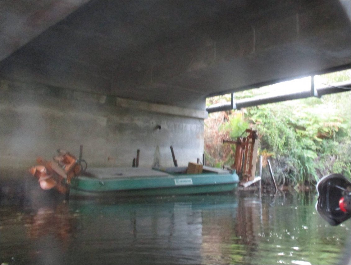Le bateau servant à l' entretien du canal avec de curieuses machineries à l' avant et à l' arrière