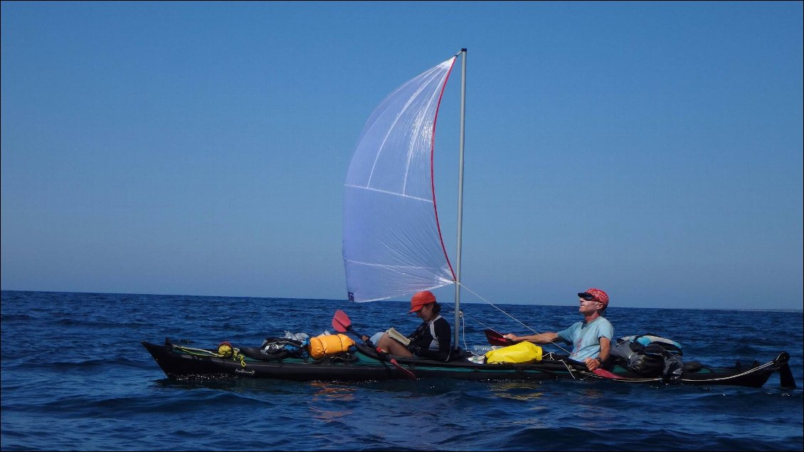 Biplace démontable sous voile (Feathercraft Klondike équipé d'origine d'un puits de mât, gréement vendu séparément). Ici la voile est placée entre les 2 pagayeurs.
L'énergie gagnée grâce à la voile (il s'agit là d'un voyage avec d'autres kayakistes sans voiles) permet au pagayeur avant de se mettre en mode "passager" :-).