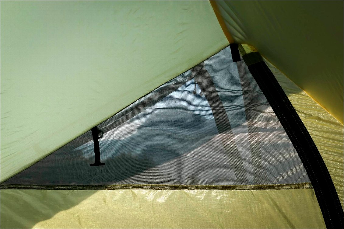 La petite fenêtre de moustiquaire en haut de la porte, en regard de l'entrée d'air.