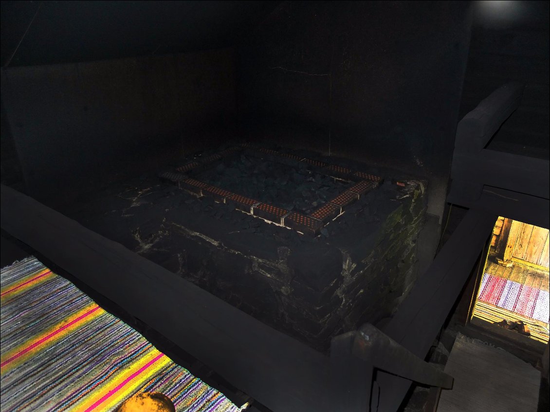 Le sol est recouvert de tapis et l'endroit est tapissé d'une fine suie puisque le four de ce sauna projette sa fumée à l’intérieur de la pièce. L'odeur suave du bois brûlé est permanente.