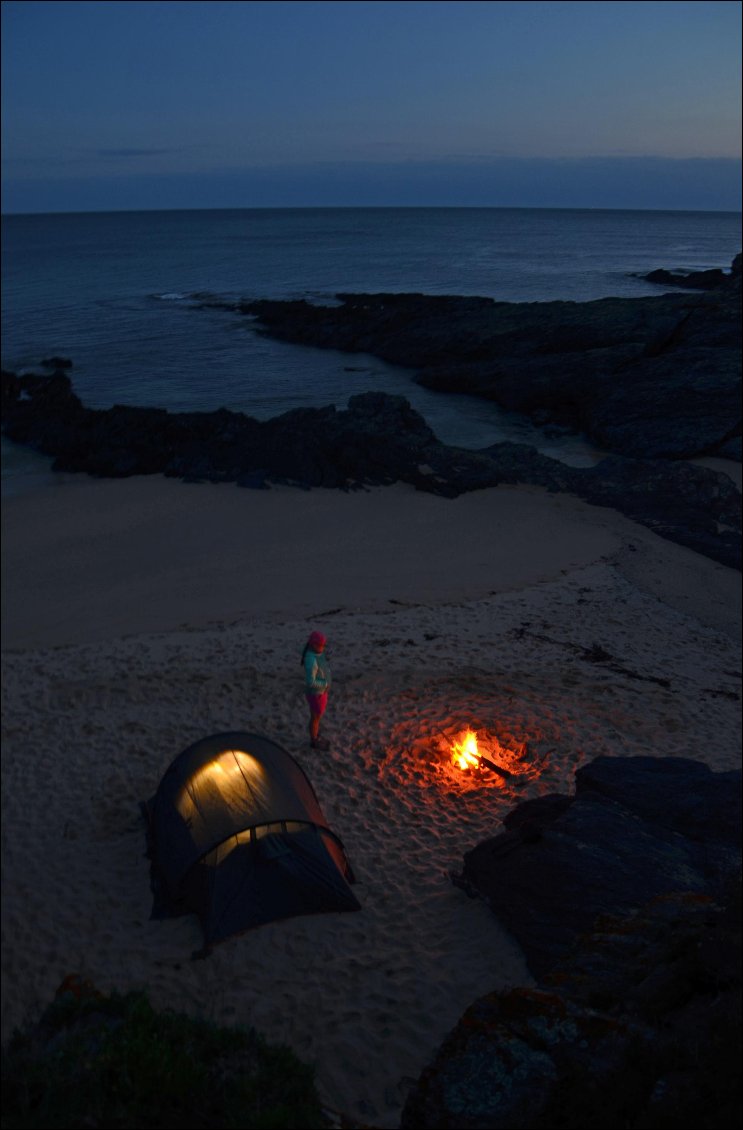 21# Morgane BURAY.
Quand l’obscurité rencontre la lumière du bivouac. Un instant paisible et mystique sur la plage de Locqueltas, lors de notre tour de l’Île de Groix à pied en duo.