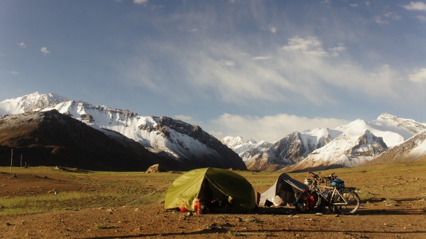 Loris OLMS.
Bivouac dans le Pamir.
Le soleil se lève sur notre bivouac au pied du plus haut col de la route du Pamir que nous devons franchir ce matin. La nuit nous a réservé une surprise. Elle a saupoudré les montagnes alentour d'une fine couche blanche. Contempler le résultat nous donne de bonnes énergies pour la rude journée qui nous attend.