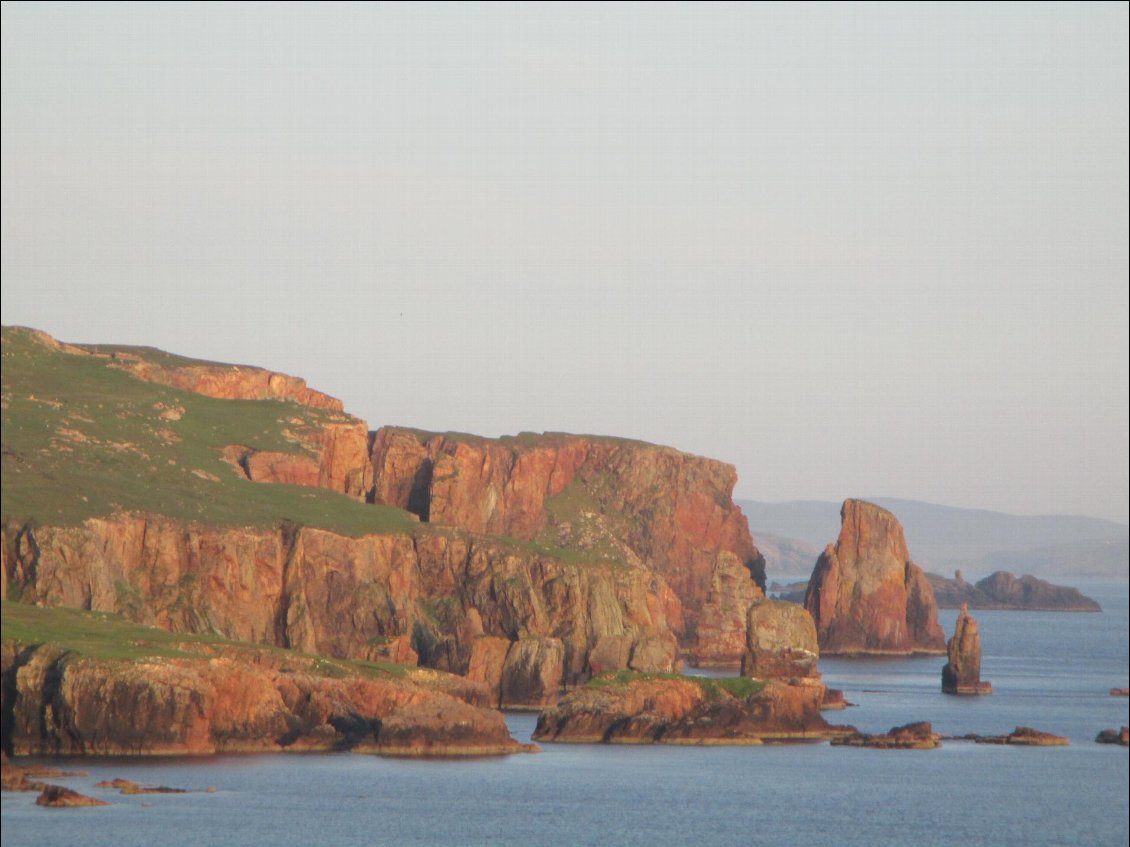 Dans le soleil couchant, les falaises paraissent encore plus rouges. Dans cette région du Nord Ouest, la roche est d'origine volcanique.