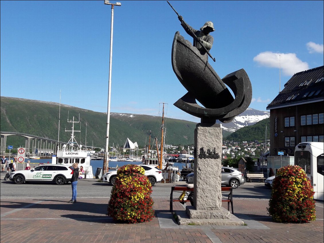Fière statue à Tromso ; au fond, la cathédrale Artique.