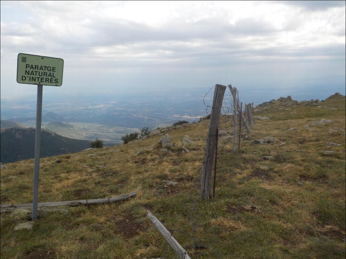 J2. Clôture-frontière après avoir contourné le pic Neulos par le nord qui est occupé par des relais. Le panneau désigne un lieu d’intérêt naturel et non la notion de « partage » comme je l’avais interprété en voyant cette frontière de barbelé.