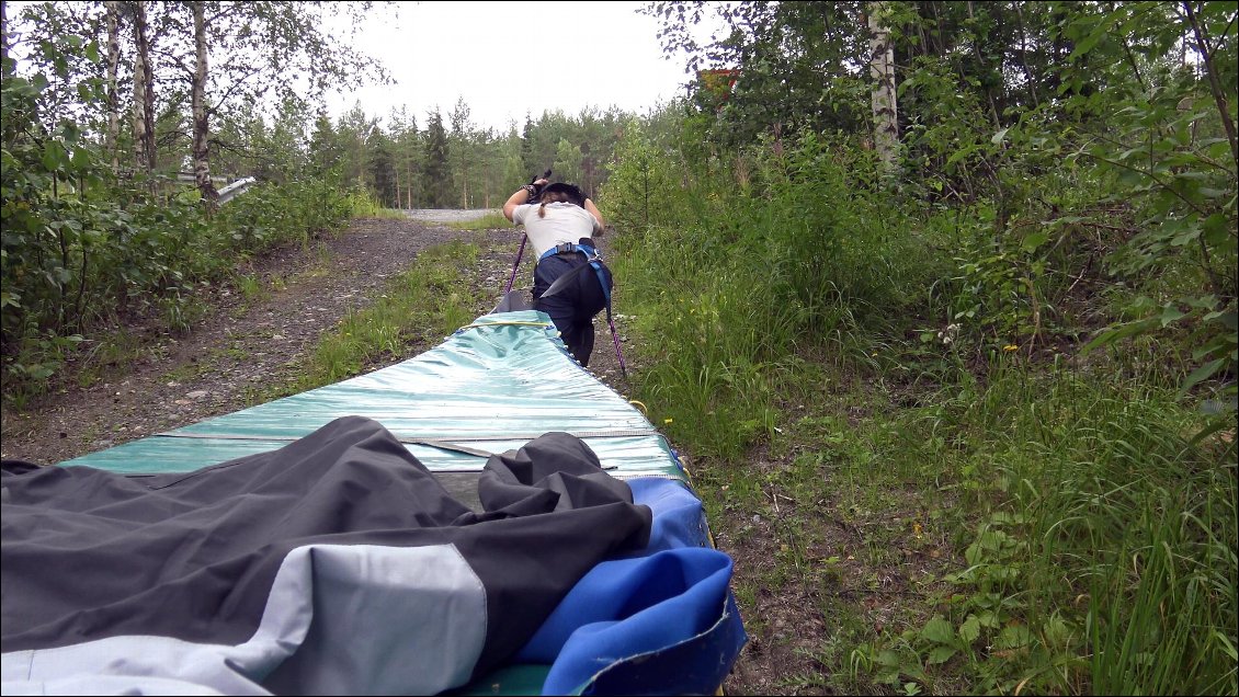 Amélie s’engage dans la montée qui mène sur la nationale et je reste derrière elle pour l’aider à pousser la poupe de son canoë, pendant que je tire le mien, ou plutôt pendant que mon canoë me tire en arrière de tout son poids, bien plus conséquent que celui d’Amélie. Nous gravissons ainsi les trois quart de la côte, puis Amélie bloque, elle n’arrive plus à avancer, le poids de son canoë commence à l’entraîner en arrière, la rendant immobile sur ses jambes, elle se fige complètement penchée vers l’avant en tant que contrepoids.