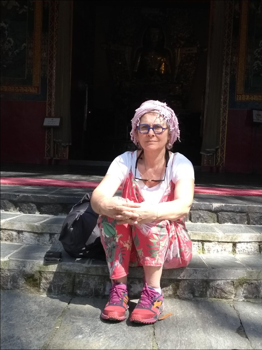 Béa assise devant le temple du Dalaï Lama.