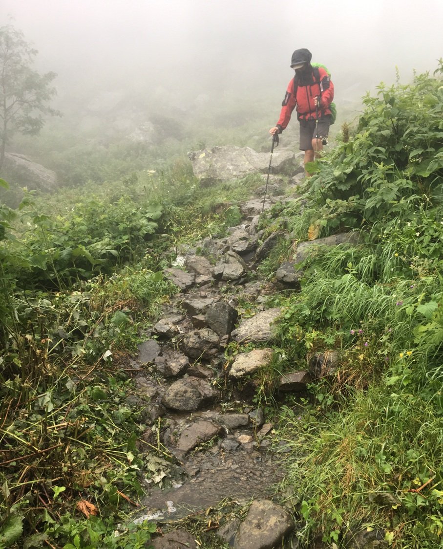 La pluie transforme les chemins en ruisseaux et rend les pierres glissantes.