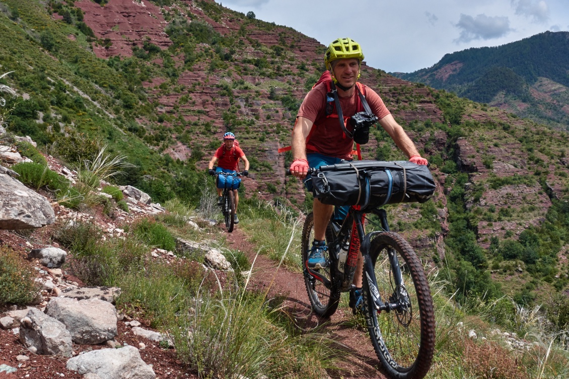 Le gilet est ici roulé dans le packraft, lui-même accroché au guidon. Hyper compact ! (photo : Sebastien Langlais)