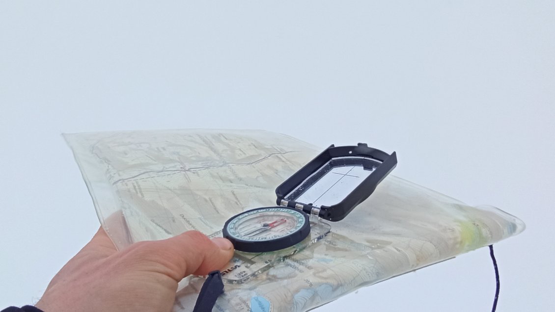 J7. La suite c'est plein de galères pour chercher mon chemin sur un terrain accidenté dans un blanc absolu sans distinction possible de la neige et du ciel. Parfois je monte, parfois je descends sans rien voir d'autre que le bout de mes skis. Je butte sur une nouvelle pente raide sensée me mener à un col étroit, mais comme d'après mon plan elle jouxte de part et d'autre deux grosses montagnes et que je n'ai aucun moyen de savoir si je m'engage sur celles-ci ou sur mon chemin pour passer le col (en sens inverse ce n'aurait pas été un souci). Dans un terrain comme celui-ci, seul et à mon niveau, je juge le risque trop élevé car je ne maîtrise pas suffisamment de paramètres. Je me résigne donc, je fais demi-tour.