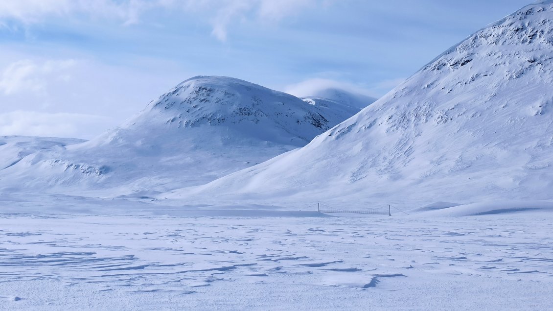 J9. Ce modèle de pont suspendu est répété plusieurs fois sur la Kungsleden. Ils sont empruntés l'été par les randonneurs et les autochtones. En hiver ils ne sont pas utiles puisque tout est gelé (traversée de la rivière sur la glace).