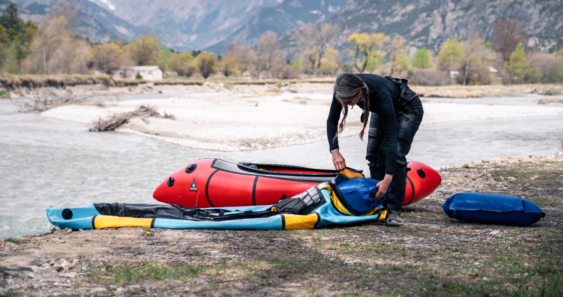 Johanna glisse un des sacs étanches prévus pour se loger parfaitement dans le packraft. C'est le système Cargo Fly.