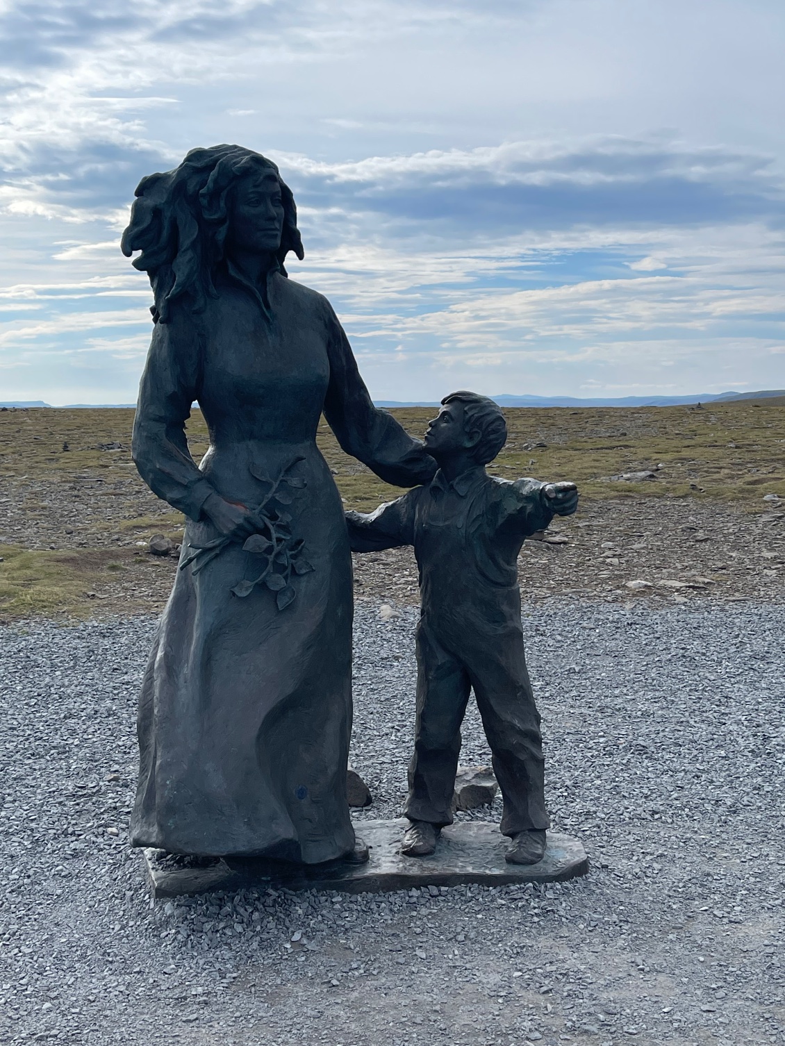 Une figure féminine et un petit garçon qui montre du bras gauche les reliefs