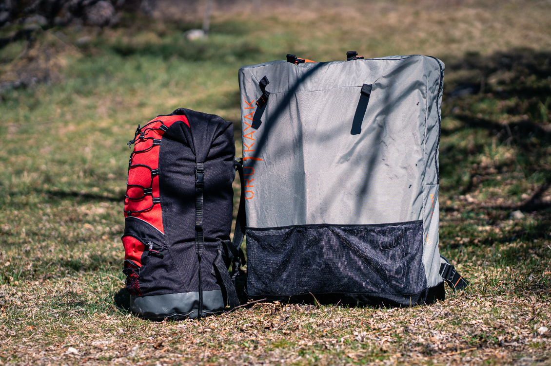 Le sac de portage en gris, comparé à un sac étanche de 80L.