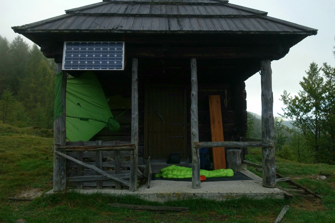 Il arrive souvent que les cabanes soient fermées. C'est frustrant, elle sont là, je les laisserais dans le même état si ce n'est plus propre et avec une plus grande réserve de bois, mais me retrouve à dormir sous le porche. Ici comme le vent fort fait tomber la pluie presque horizontalement, j'ai installé mon tarp tel une voile de bateau pour me protéger de la pluie. Le trou de la capuche permet d'atténuer la force du vent sur la toile. Il y a toujours de nouvelles fonctions à inventer avec son matériel pour s'adapter.