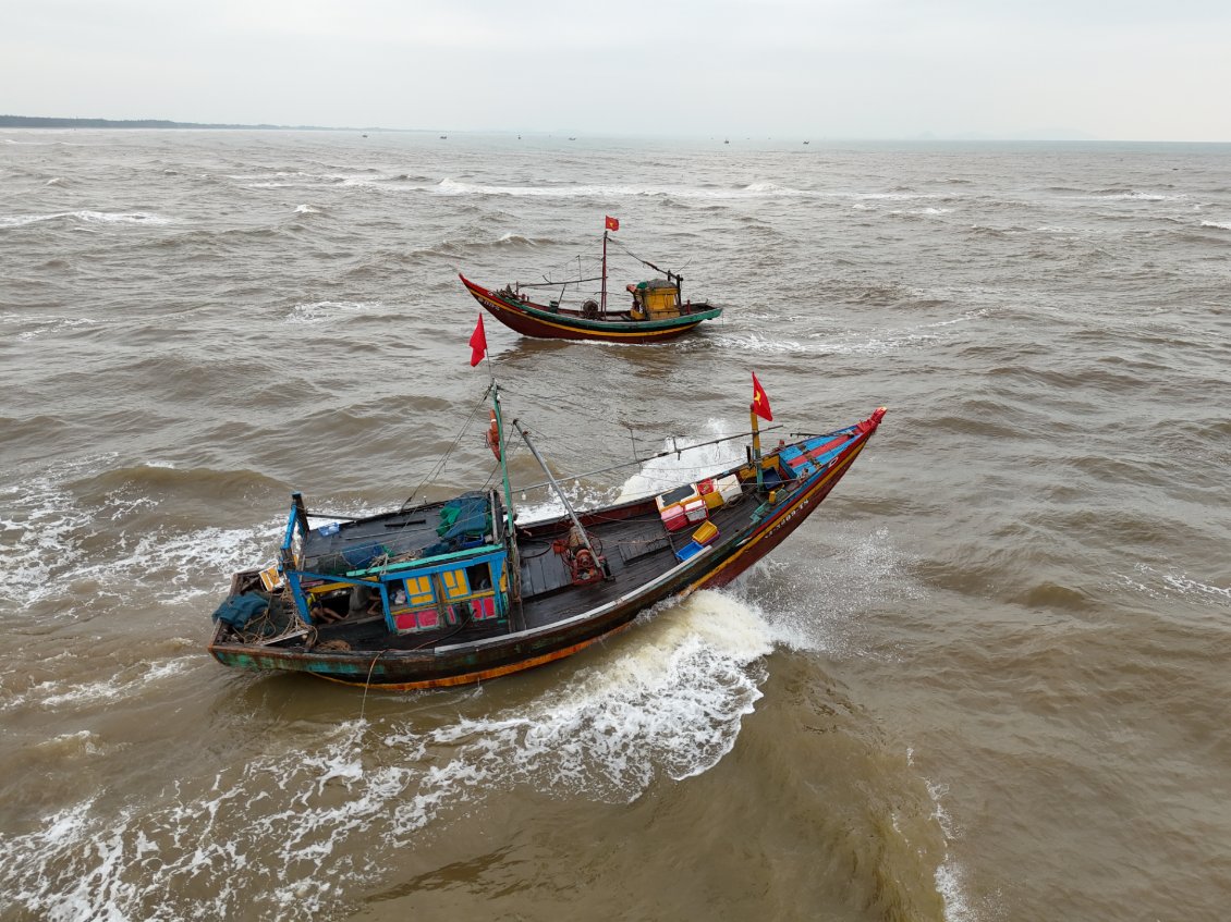 J19. Deux bateaux de pêche se croisent en mer agitée. L'un rentre, pendant que l'autre sort.