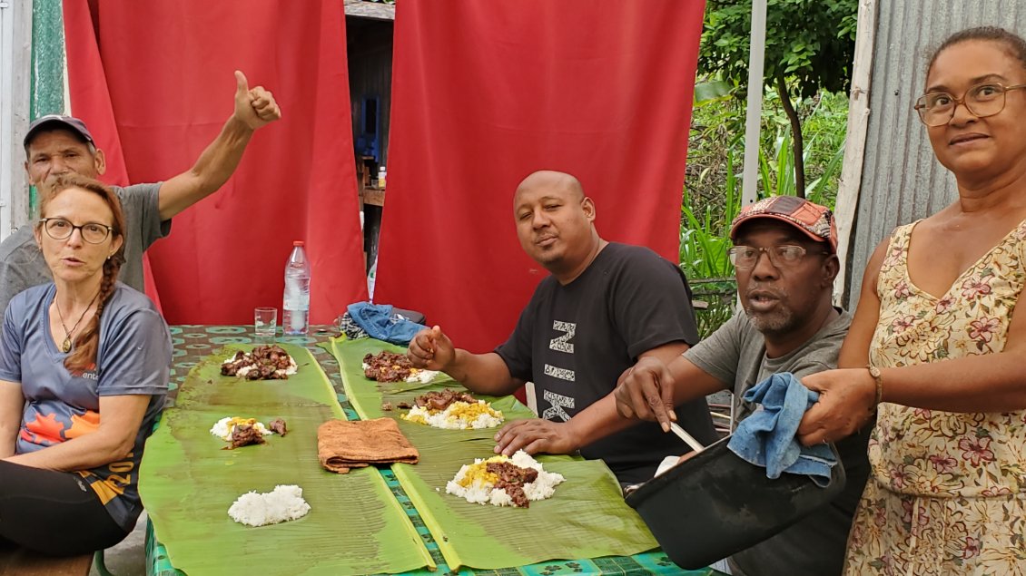 repas partagé Rougail saucisse et carry de tangue avec les doigts sur une feuille de palmier.