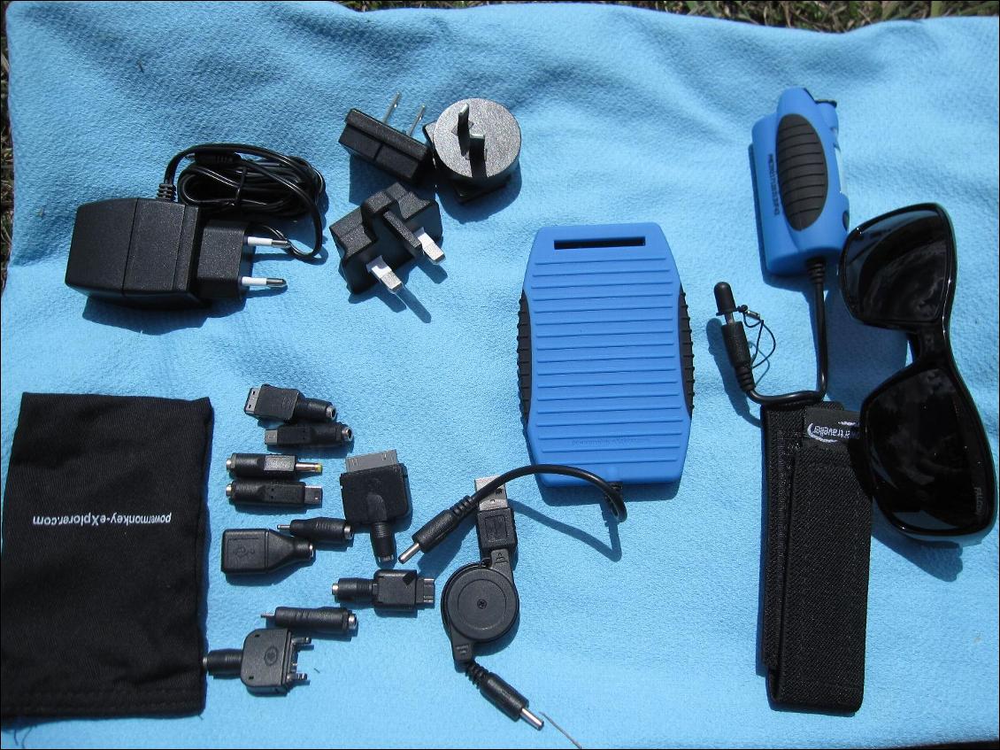 Panneau pliable rigide (ici replié) avec avec batterie séparée Powermonkey Explorer + accessoires fournis (connectique + housse + velcro de fixation)
