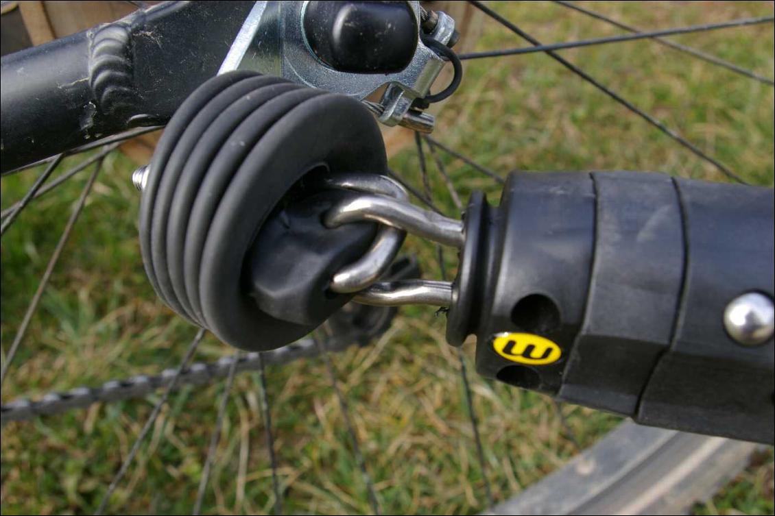 Fixation au vélo : système Weber articulé et sécurisé avec un câble en acier, facile à mettre en place mais d'expérience (sur remorque Weber Monoporter) fragile