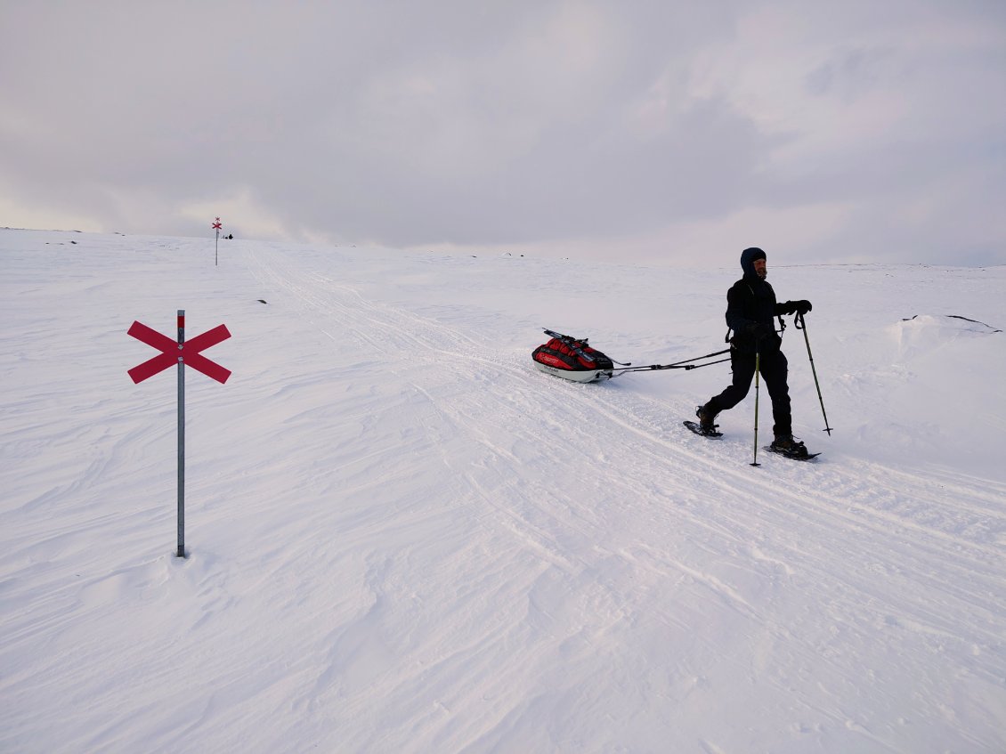J15. Dans une descente trop raide sur neige gelée pour que je la tente à skis, c'est Gilles qui retient la pulka avec ses raquettes. Un vrai travail d'équipe.
