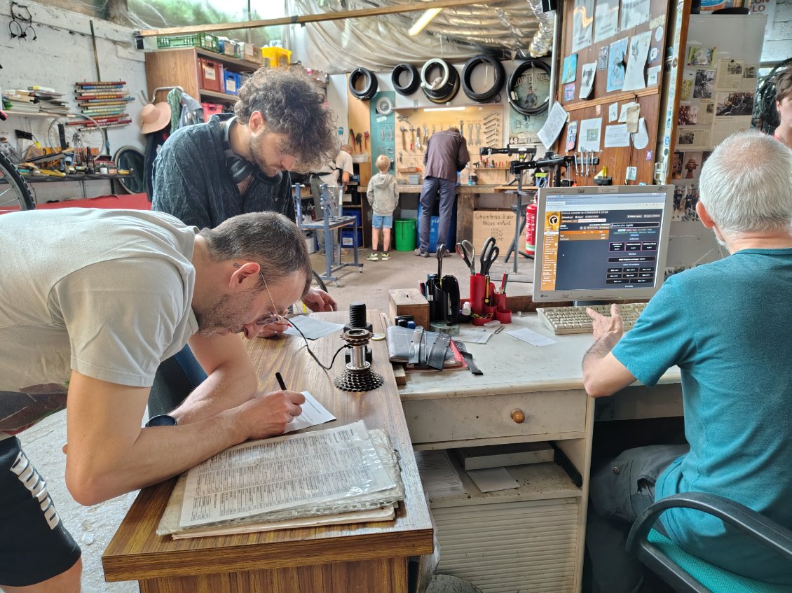 Préparation du vélo dans un atelier collaboratif avant le départ.