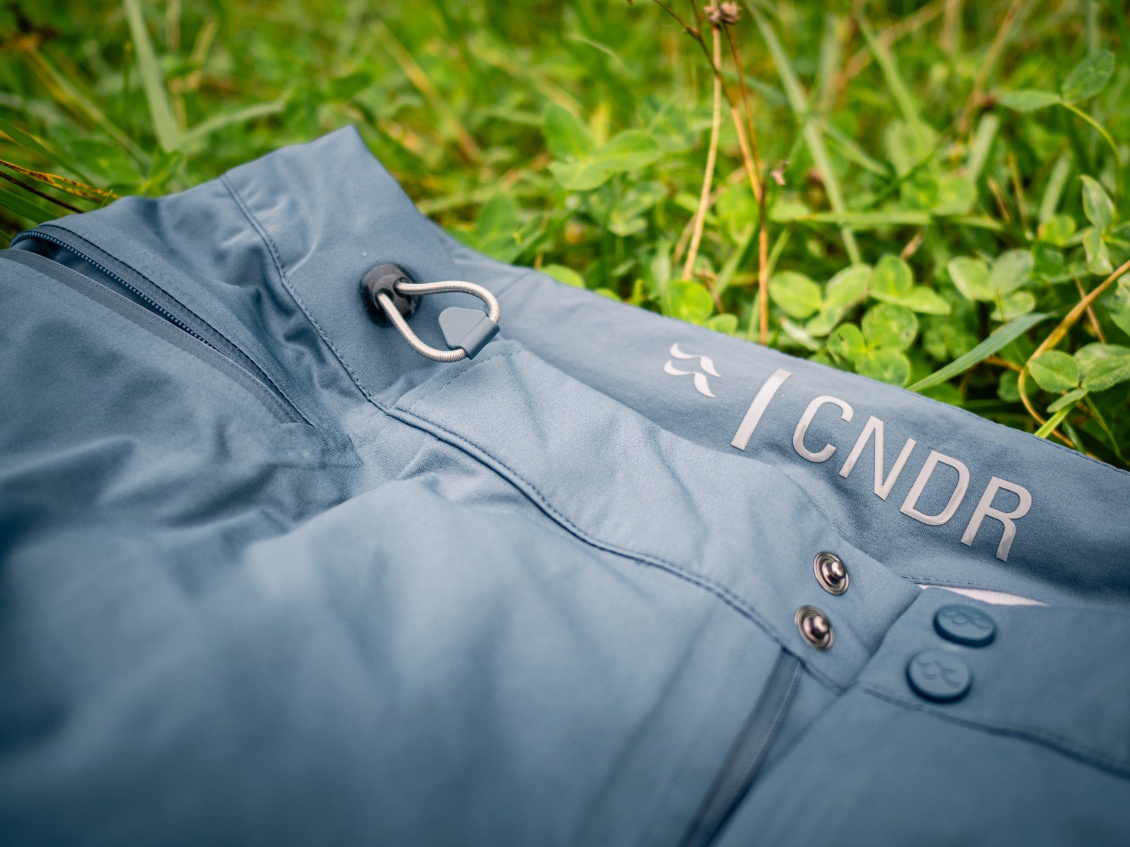 Système de serrage simple. L'inscription "CNDR" et le logo sont "siliconés" pour bien maintenir le pantalon.