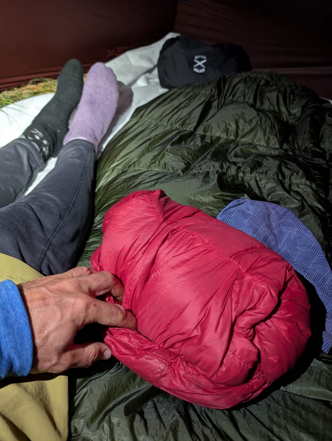 Oreiller encore plus minimaliste : la doudoune rentrée dans sa capuche, enveloppé dans un buff pour maintenir l'ensemble.