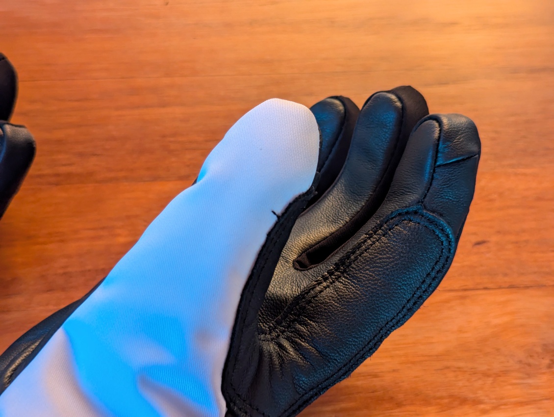 Renforts supplémentaires en cuir entre pouce et index, zone d'usure plus importante due au passage/frottement avec les suspentes, un bâton, un piolet...