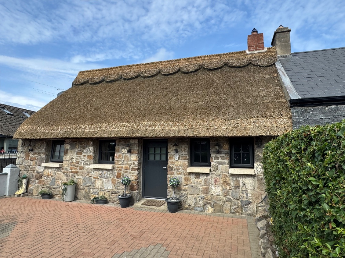 Un joli cottage en pierre et toit de chaume travaillé 
